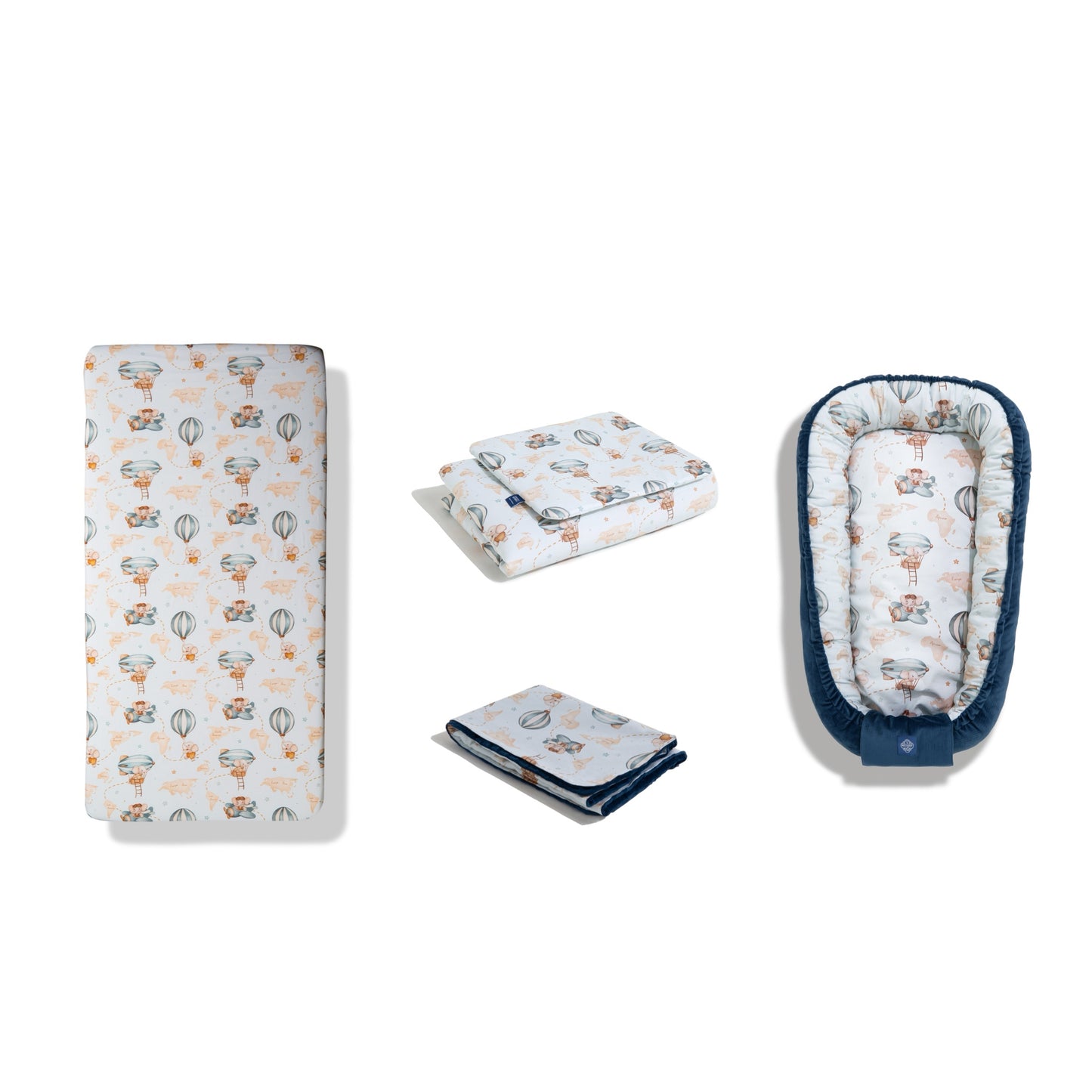 Baby bedding set in ‘Sky Dreamer’ print, including fitted sheet, duvet cover, blanket, and baby nest. Top-down view of the set